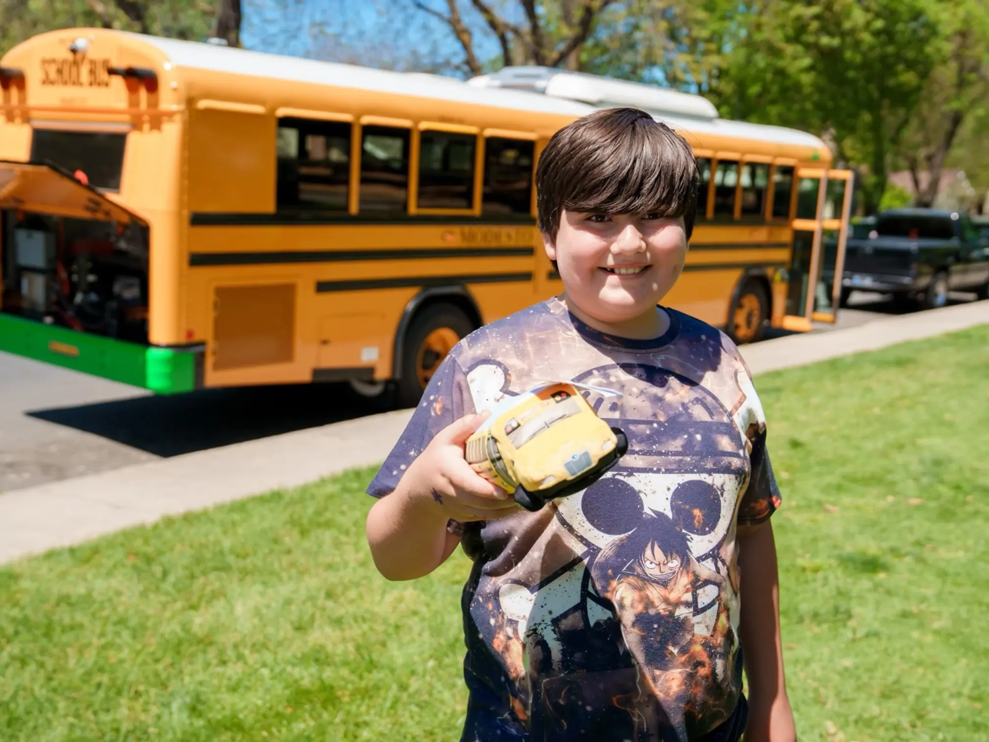 Student standing near an electric school bus